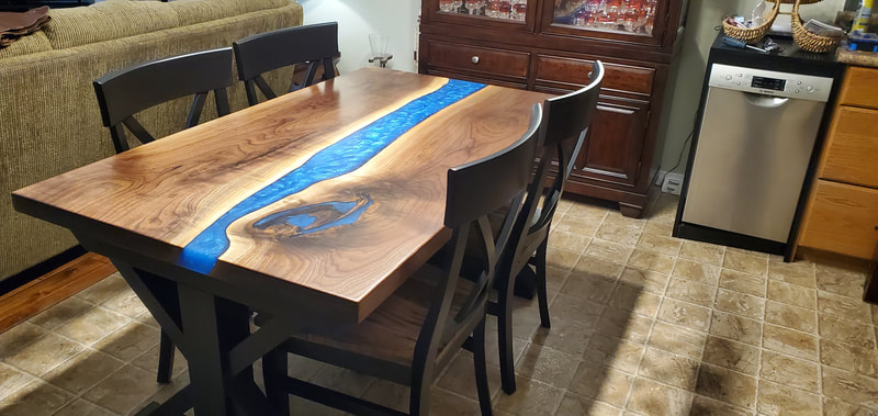 Custom Live Edge epoxy river table with blue epoxy and wood sawbuck table base in Kitchener Ontario