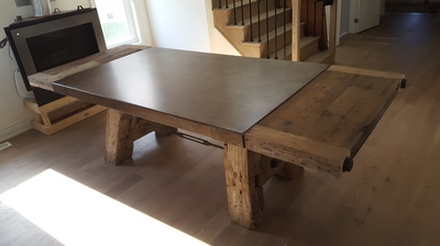 Reclaimed wood and distressed steel dining table with extensions in Etobicoke Ontario.